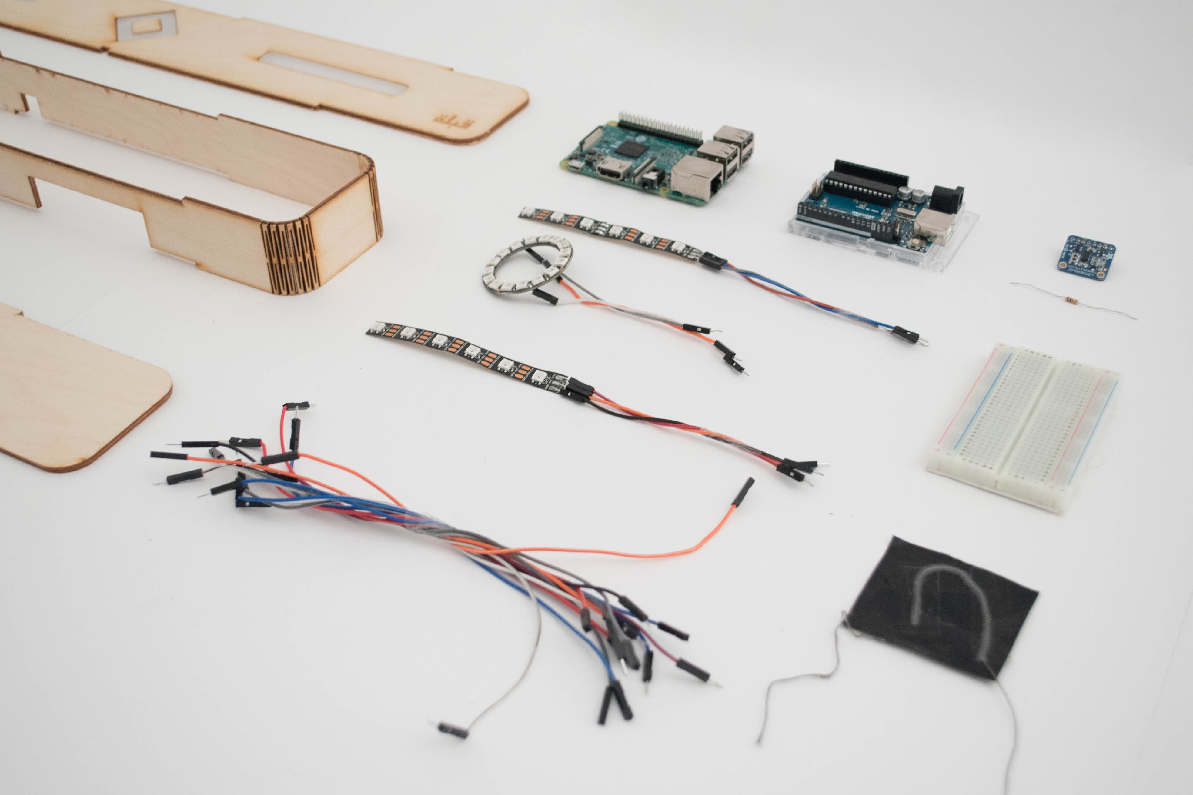 Components: laser-cut wood enclosure, Raspberry Pi, Arduino, NeoPixel LED strips, magnetometer, jumper wires, breadboard.